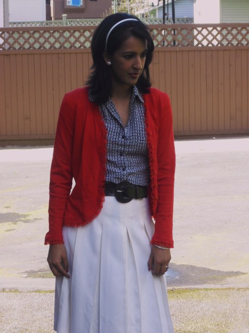 white skirt, printed navy blouse, red cardigan
